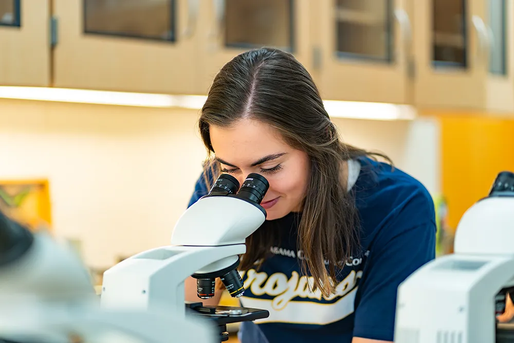 Student looking into microscope