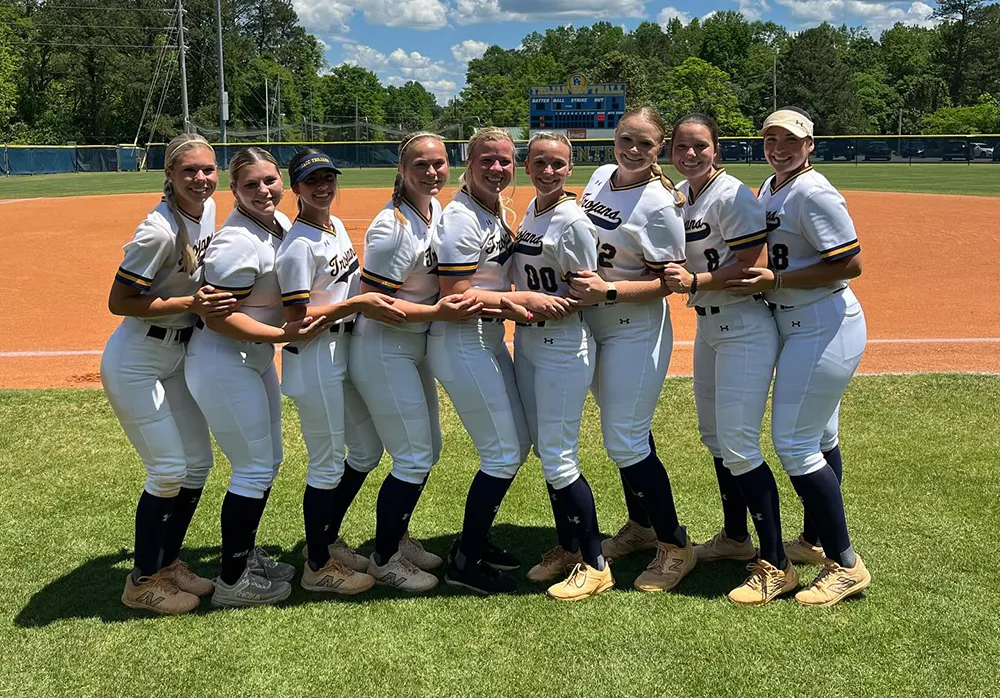 Softball team posing for photo on field